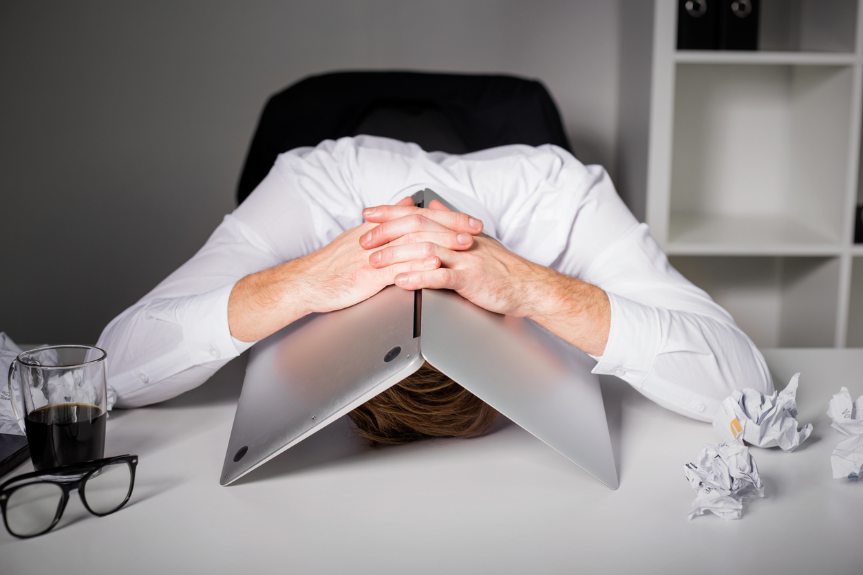 man hiding under laptop